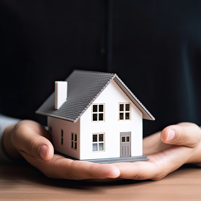 woman showing with one hand a mini house. Real state concept.